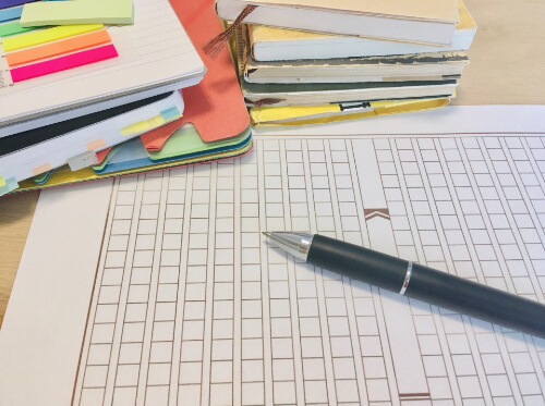 積まれた書類とペン